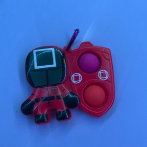 Squid game pop it two pop, its on the right side, red and black